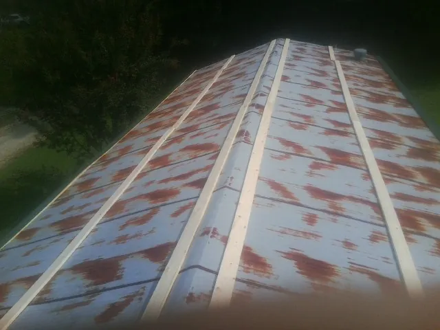 Rusted metal roof panels with new wood purlins before replacement — Storm Damage Roof Repair in Christiana by Roofing Brothers