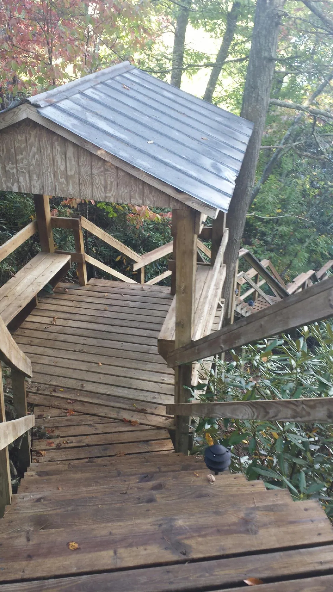 Metal roofed shelter over wooden steps on a wooded walkway — Skylight Repair & Installation work by our crew in Christiana
